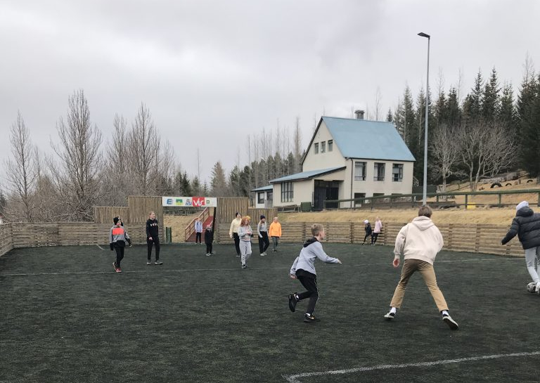 Krakkar í fótbolta á malarvelli