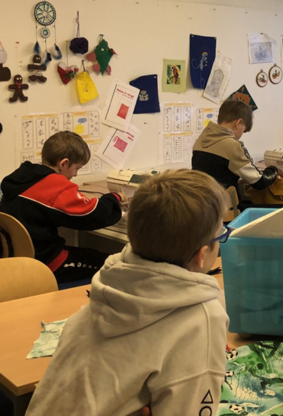 Þrír grunnskólanemendur í kennslustund.